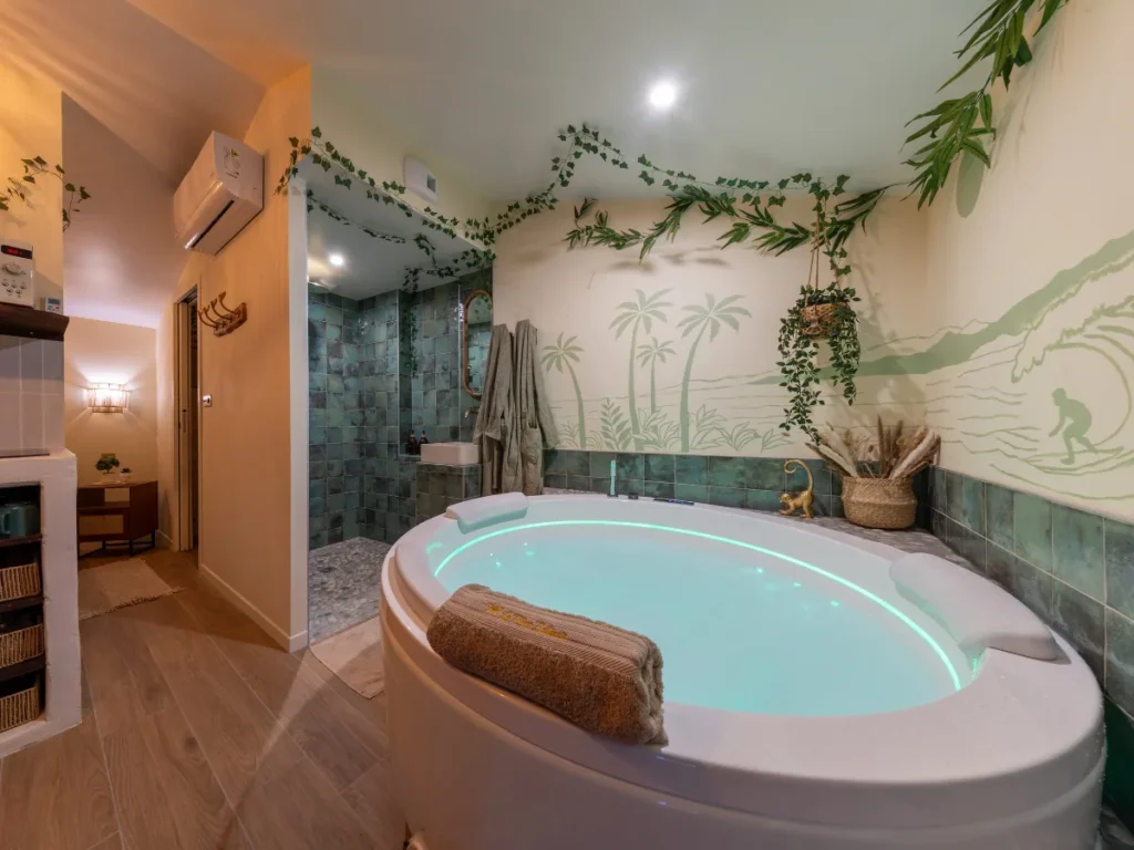 Balnéo privatisée éclairée en vert dans le décor Bali du Rêve Balinais, La Tranche-sur-Mer