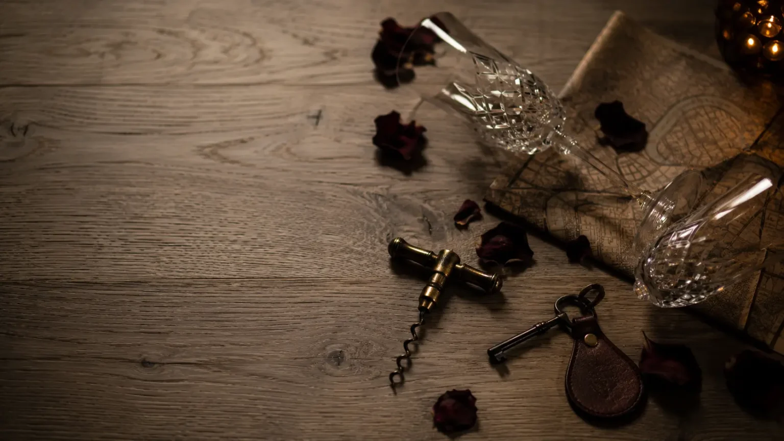 Verres, clé de chambre et plan de ville évoquant une love room Bordeaux pour une nuit en amoureux